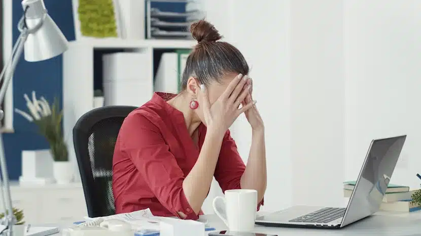 Femme qui se tient la tête à cause du stress, afin d'illustrer les difficultés de gérer un blog